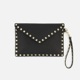 The Rockstud Medium Flat Pouch by VALENTINO GARAVANI is crafted from textured black leather in an envelope silhouette, accented with gold-tone square rockstuds outlining the edges and a matching studded wrist strap attached to one side. The pouch features a flap closure for secure storage.