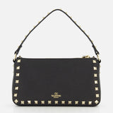 The Rockstud Small Shoulder Bag by VALENTINO GARAVANI is a black leather shoulder bag with gold-tone rockstud trim, a removable strap, and a small gold logo on the front.