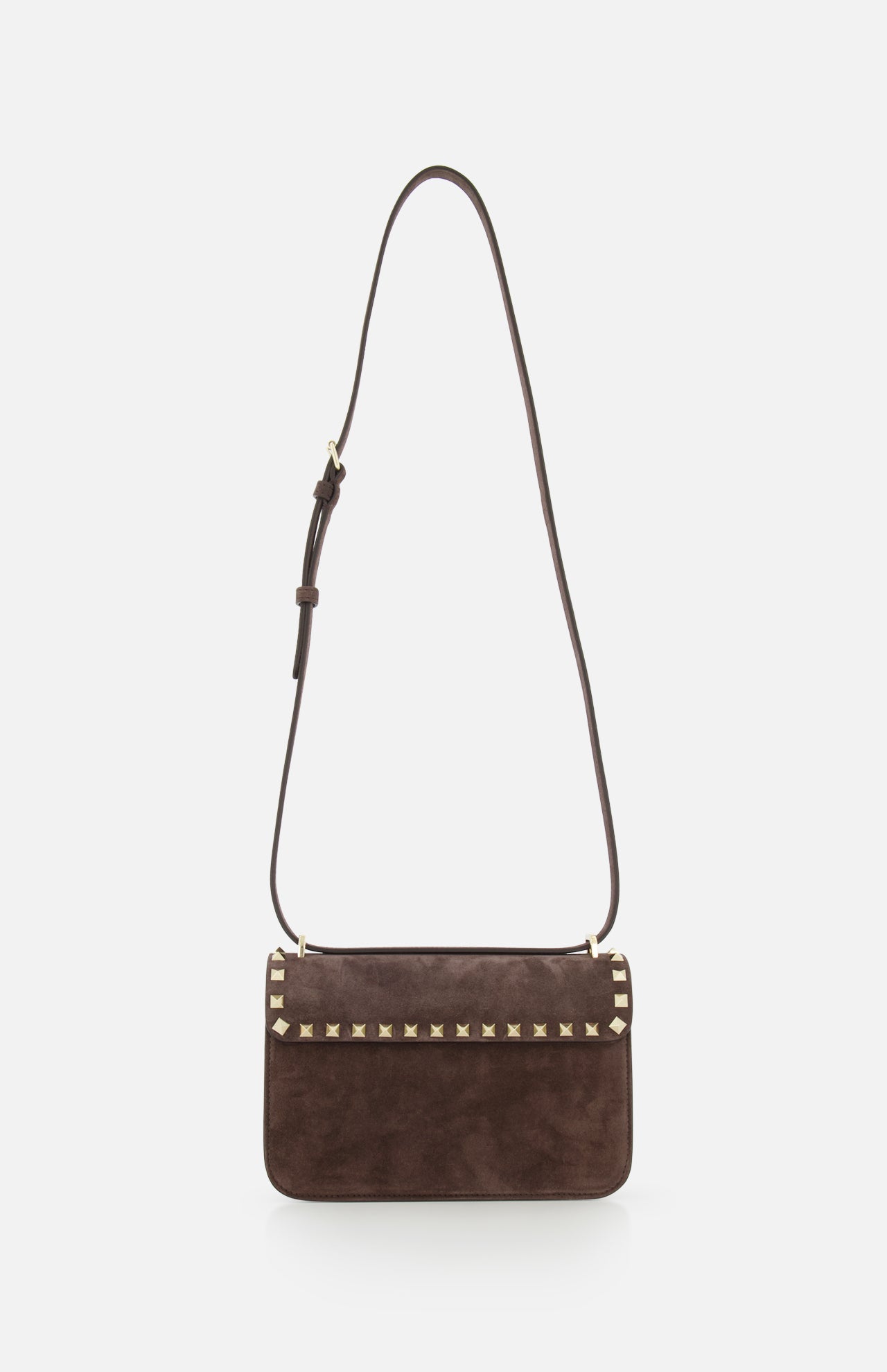 The VALENTINO GARAVANI Rockstud Small Suede Shoulder Bag features brown suede, a flap closure, signature rockstud trim along the edge, and an adjustable strap, shown against a white background.