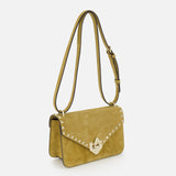 The VALENTINO GARAVANI Rockstud Small Shoulder Bag in mustard yellow suede features gold hardware, an adjustable strap, and a flap closure with signature rockstud trim. Shown on a plain white background.