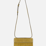 The VALENTINO GARAVANI Rockstud Small Shoulder Bag in mustard yellow suede features a flap closure, gold-tone rockstud trim along the edge, and an adjustable strap. It is displayed against a plain white background.
