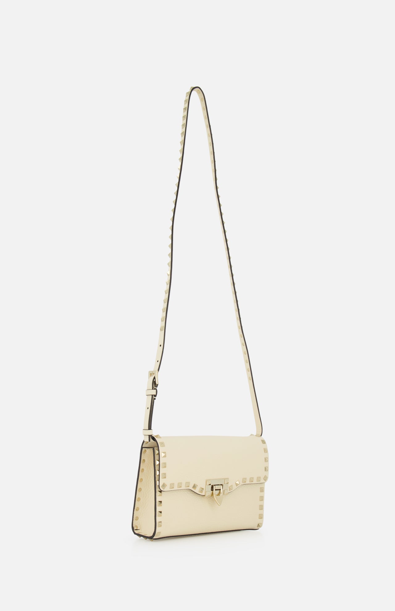 The Rockstud Small Shoulder Bag by VALENTINO GARAVANI is a cream-colored leather crossbody featuring a long strap, gold clasp, and signature square stud accents along the edges, shown against a plain white background.