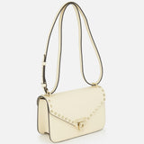 Valentino Garavani Rockstud Small Shoulder Bag in ivory leather featuring gold-tone pyramid studs along the flap and a turn-lock closure.