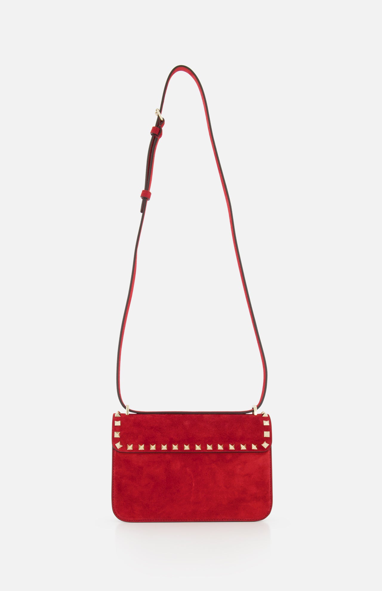 The VALENTINO GARAVANI Rockstud Small Suede Shoulder Bag in lipstick red features rockstud trim on the top flap and an adjustable matching strap, displayed against a plain white background.