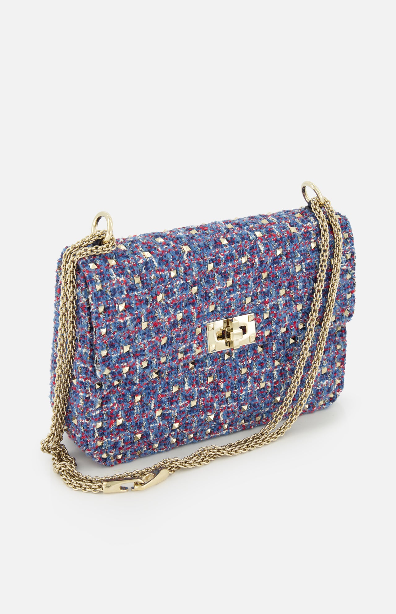 The VALENTINO GARAVANI Rockstud Spike Medium Shoulder Bag is a small, rectangular, multicolored tweed bag featuring a gold turn-lock clasp and a long gold chain strap, displayed on a white background—perfect as an elegant shoulder bag for any occasion.