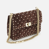 The VALENTINO GARAVANI Rockstud Spike Medium Shoulder Bag in dark brown suede features quilted detailing and micro rockstuds accenting its gold chain strap and clasp closure, displayed against a white background.