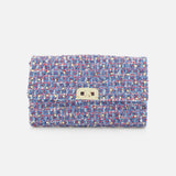 The Rockstud Spike Shoulder Bag by VALENTINO GARAVANI is a rectangular shoulder bag crafted from textured, multicolored tweed fabric, featuring a gold-tone turn-lock closure and a removable chain strap, displayed against a plain white background.