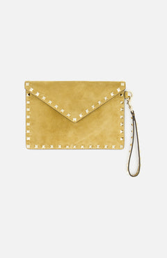 The VALENTINO GARAVANI Rockstud Suede Medium Flat Pouch is a tan suede clutch accented with signature gold-tone pyramid studs along the edges and features a detachable wrist strap, shown against a white background.