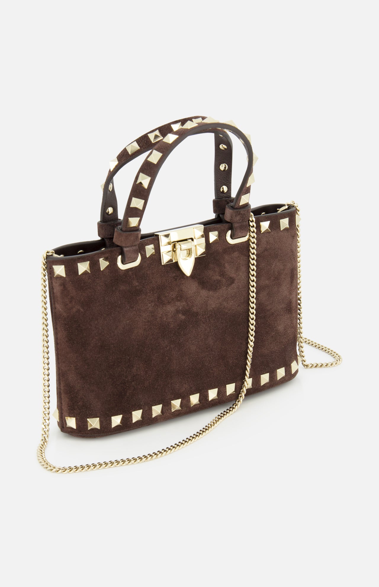 The VALENTINO GARAVANI Rockstud Suede Mini Bag is crafted from dark chocolate brown suede and embellished with gold pyramid studs. It features a top handle, a removable chain strap, and a gold hardware clasp, shown here against a white background.