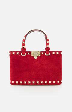 The VALENTINO GARAVANI Rockstud Suede Mini Bag features red suede, gold pyramid studs, dual handles, a detachable chain strap, and a gold clasp closure, shown against a plain white background.