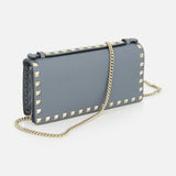 The VALENTINO GARAVANI Rockstud Wallet with Chain Strap is a blue leather purse featuring gold pyramid studs along the edges and a gold chain strap, shown on a white background.