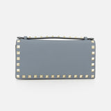 The VALENTINO GARAVANI Rockstud Wallet with Chain Strap is a rectangular light gray party purse, featuring gold pyramid studs outlining the edges, set against a plain white background.