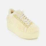 The VALENTINO GARAVANI Royco Shearling Platform Sneaker is shown at an angle on a white background, featuring a cream-colored shearling upper with a fuzzy texture, cream laces, a thick platform heel, and subtle logo detailing for a touch of signature style.