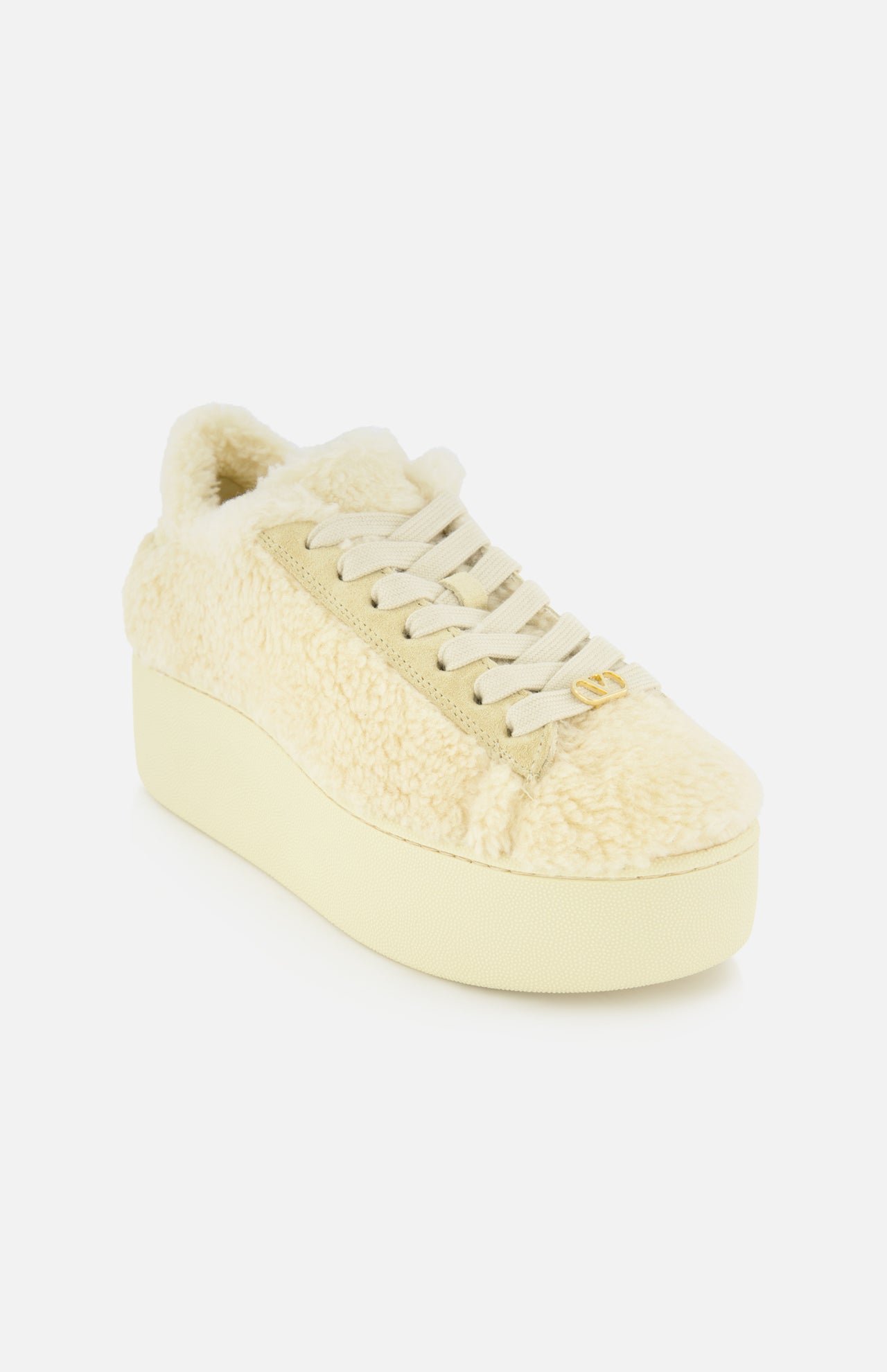 The VALENTINO GARAVANI Royco Shearling Platform Sneaker is shown at an angle on a white background, featuring a cream-colored shearling upper with a fuzzy texture, cream laces, a thick platform heel, and subtle logo detailing for a touch of signature style.