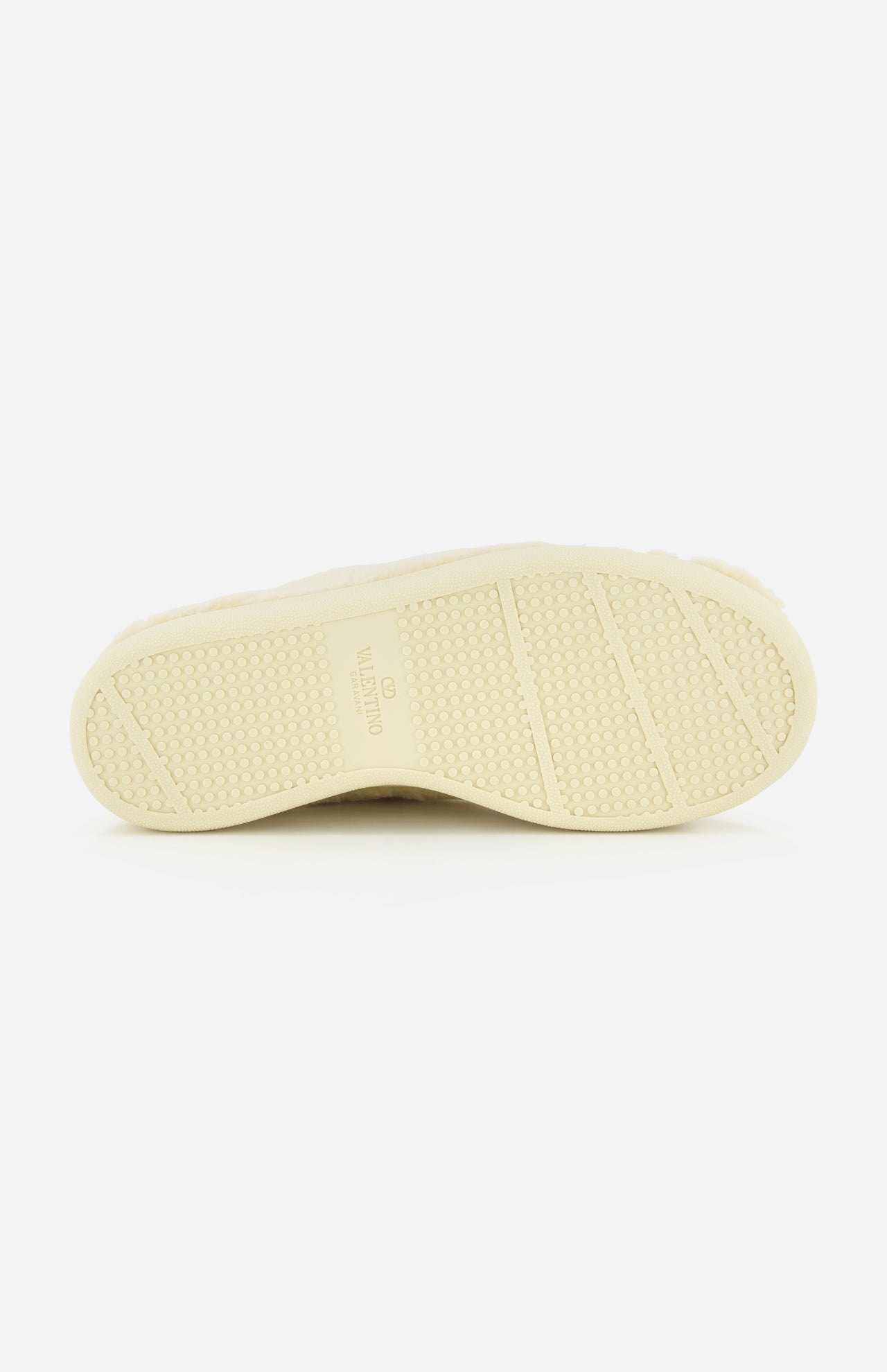 The image features the light-colored, textured rubber sole of the VALENTINO GARAVANI Royco Shearling Platform Sneaker, accented with subtle logo detailing and presented against a white background.