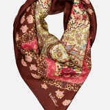 The Shawls Floral Foulard Scarf by VALENTINO GARAVANI features a rich brown border and intricate floral prints in pink, red, yellow, and green—an elegant designer accessory that adds a refined touch to any ensemble.