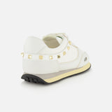 Valentino Garavani Stud Up white low-top sneakers featuring a row of rockstud trims along the heel and a layered rubber sole.