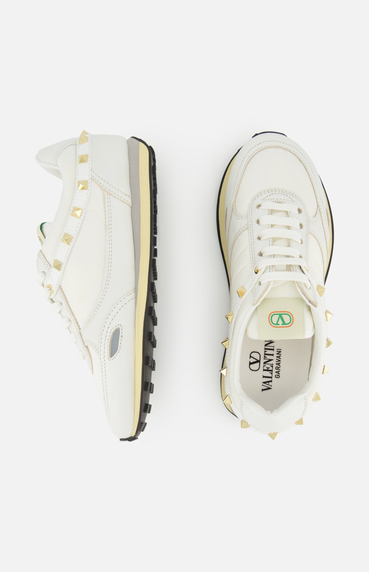 Top-down view of two white Valentino Garavani Stud Up sneakers featuring pyramid-shaped gold rockstud trims along the heels and collars.
