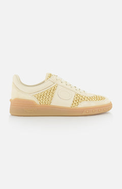 The VALENTINO GARAVANI Upvillage Raffia Sneaker features a cream and light yellow woven texture, suede accents, lace-up front, and beige rubber sole, shown in a side view on a white background.