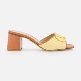 The VALENTINO GARAVANI V Logo Signature Block Heel Slide Sandal features a tan woven raffia upper, open toe, mid-height block heel, and a gold buckle, shown on a white background.