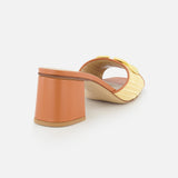 The VALENTINO GARAVANI V Logo Signature Block Heel Slide Sandal features an orange block heel and a woven beige raffia upper, shown from the back against a white background.