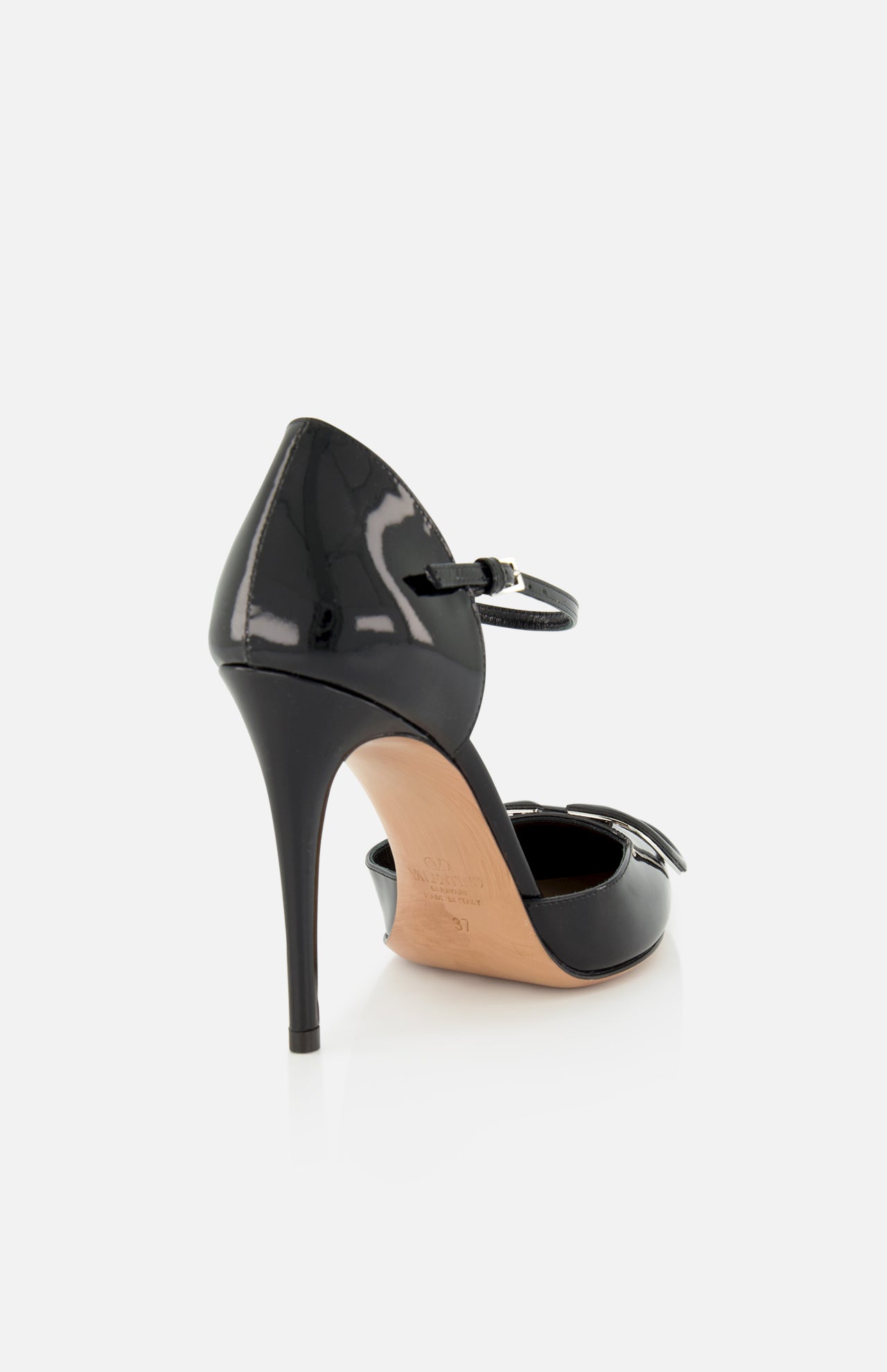 The VALENTINO GARAVANI V Logo Signature D'Orsay Heel is a black patent leather pump with an ankle strap and pointed toe, featuring a sleek silhouette showcased from the back against a light background.