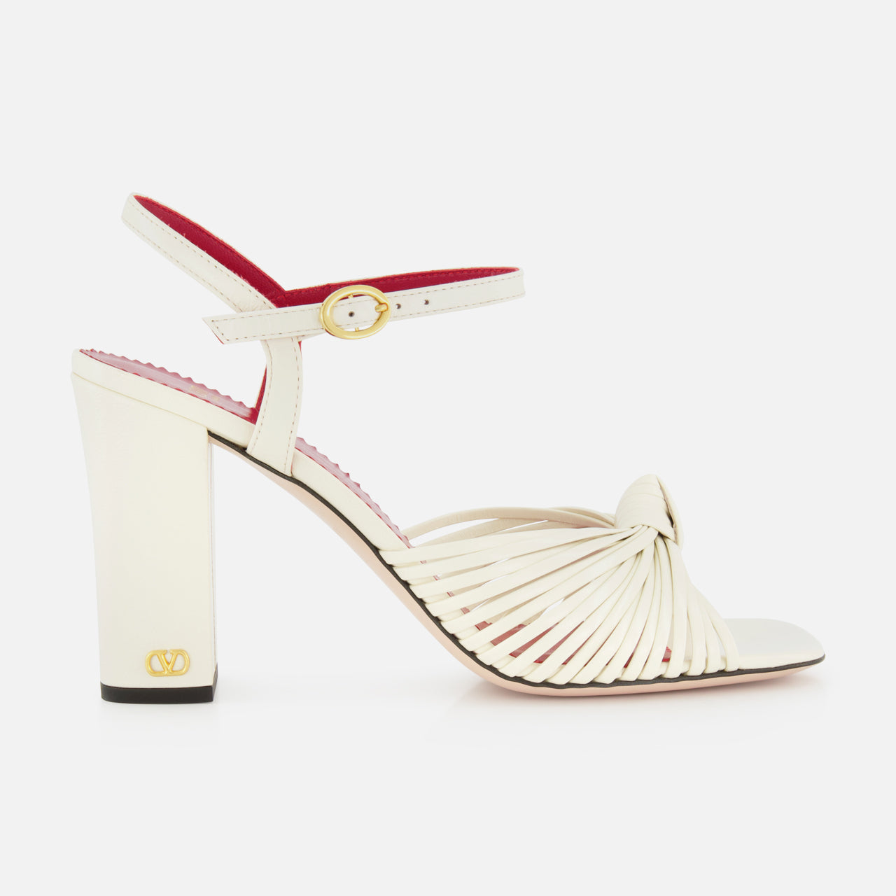 The Valentino Garavani Annet T.90 Sandal by VALENTINO GARAVANI features white knotted leather straps, a leather ankle strap with gold buckle, an ivory high heel, and a subtle VLogo accent near the sole.
