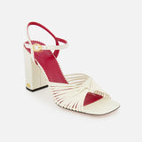 The Valentino Garavani Annet T.90 Sandal by VALENTINO GARAVANI features cream crisscross leather ankle straps, a block ivory heel, red insole, gold buckle, open toe, and an ankle strap for stylish elegance.