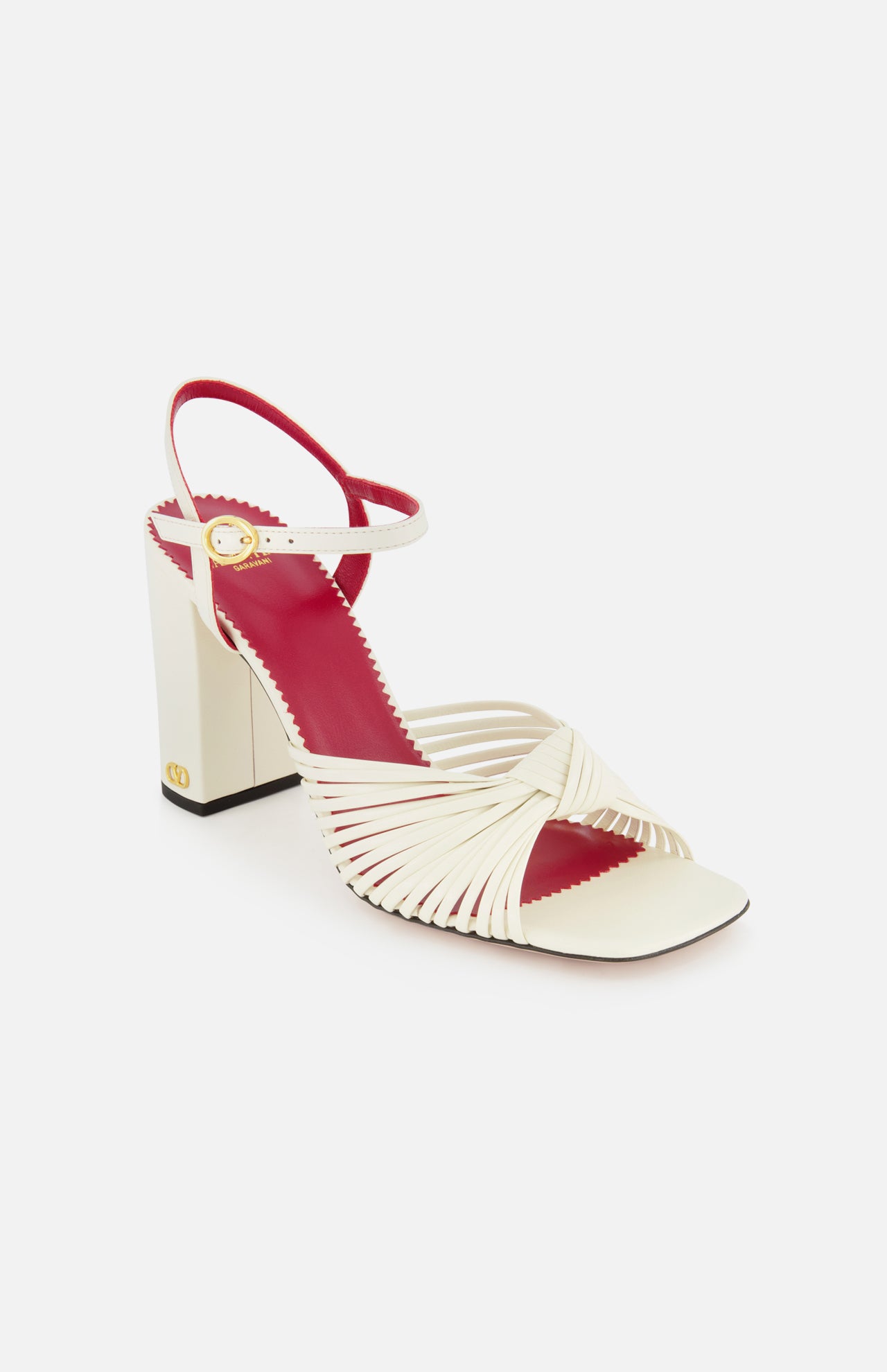 The Valentino Garavani Annet T.90 Sandal by VALENTINO GARAVANI features cream crisscross leather ankle straps, a block ivory heel, red insole, gold buckle, open toe, and an ankle strap for stylish elegance.