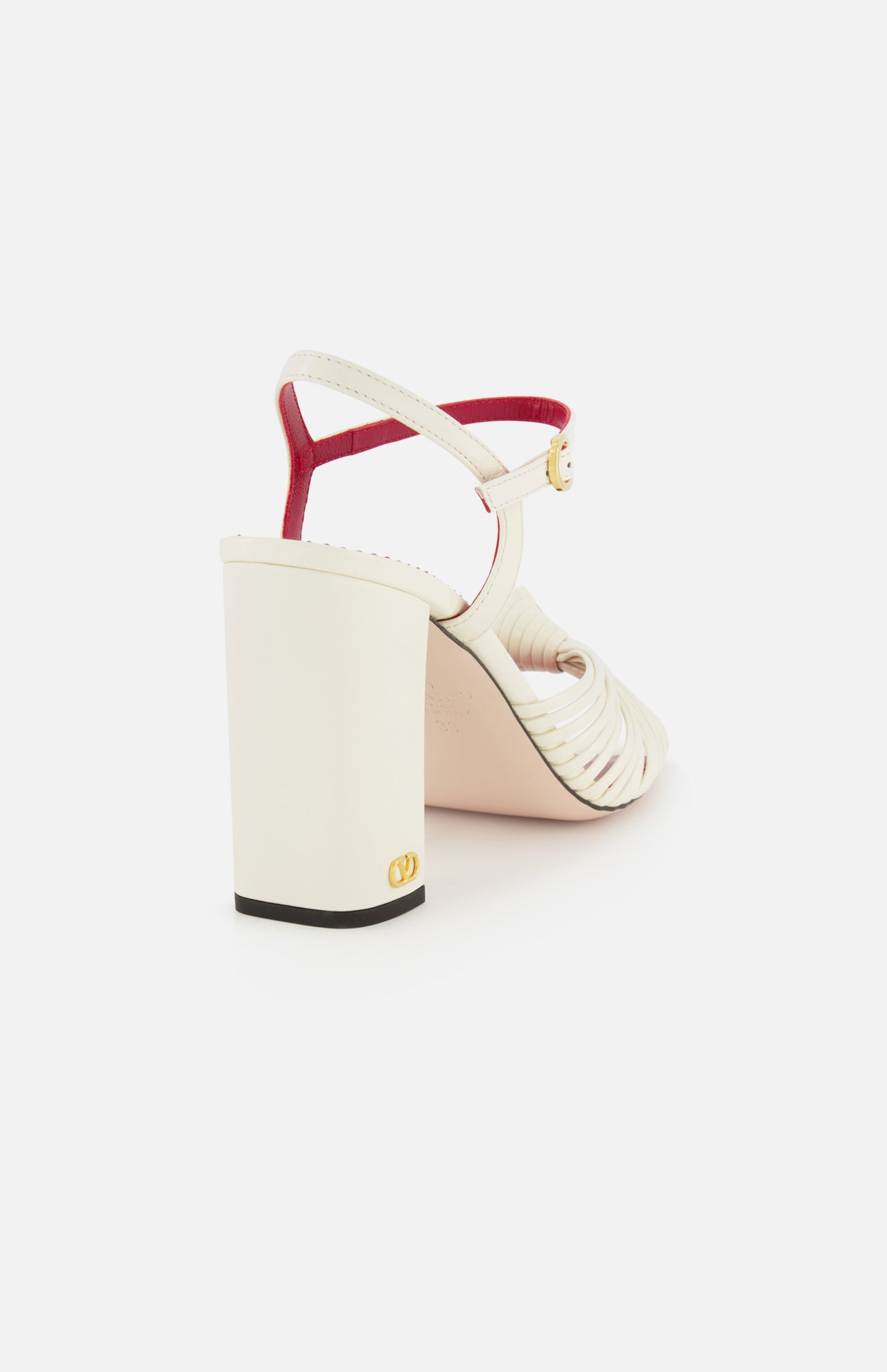 The Valentino Garavani Annet T.90 Sandal features a leather ankle strap with gold buckle, ivory block heel, red-trimmed back strap, and a signature VLogo near the heel base by VALENTINO GARAVANI.