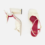 The Valentino Garavani Annet T.90 Sandal by VALENTINO GARAVANI features cream pleated leather, open toes, red insoles, an ivory heel, and a leather ankle strap. One sandal is upright; the other is shown from above on a white background.
