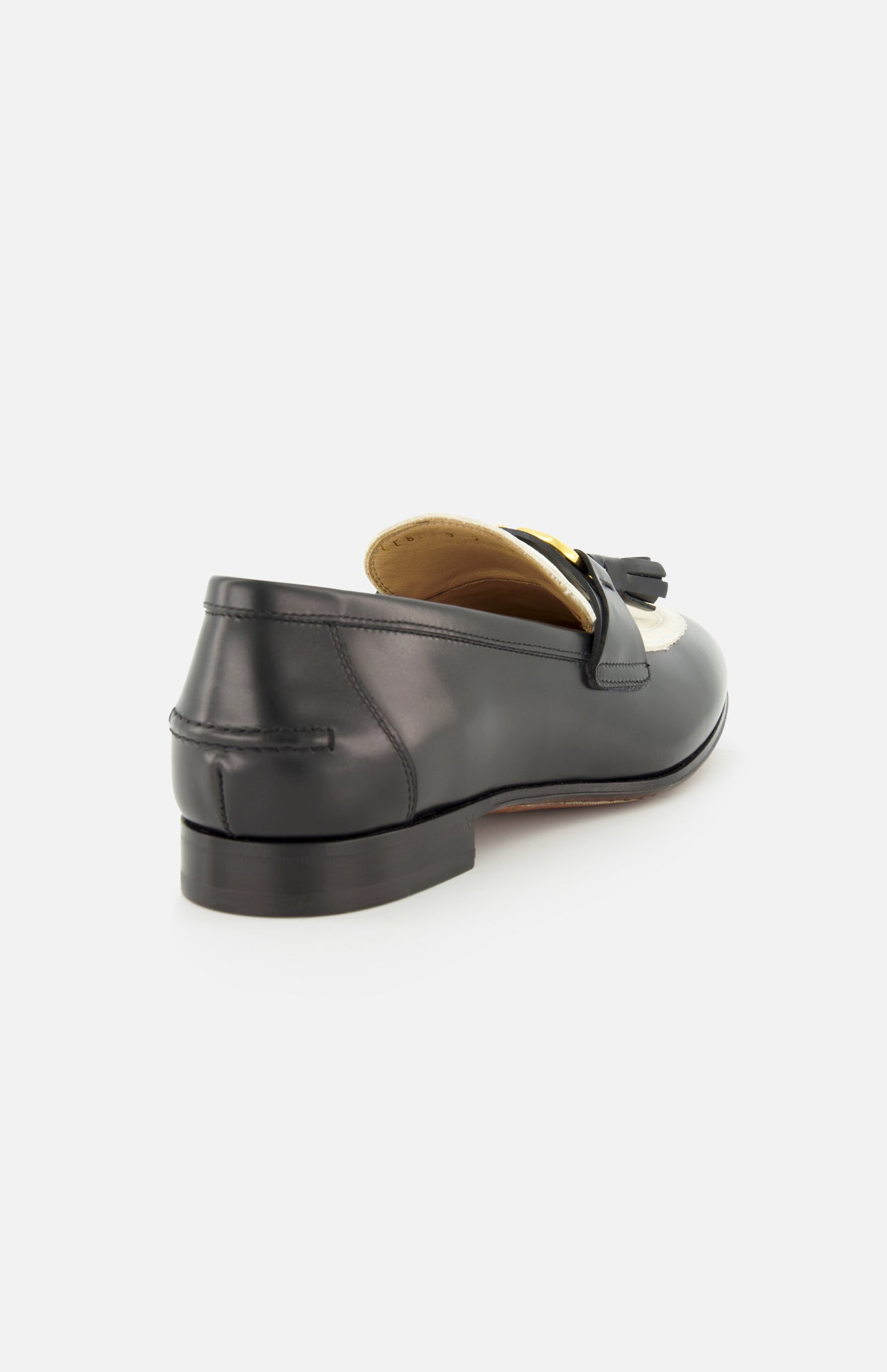 The Valentino Garavani Vaniteux Loafer by VALENTINO GARAVANI features black leather, a low heel, and tassel detail—classic women's slip-ons shown from the back side angle on a plain white background.