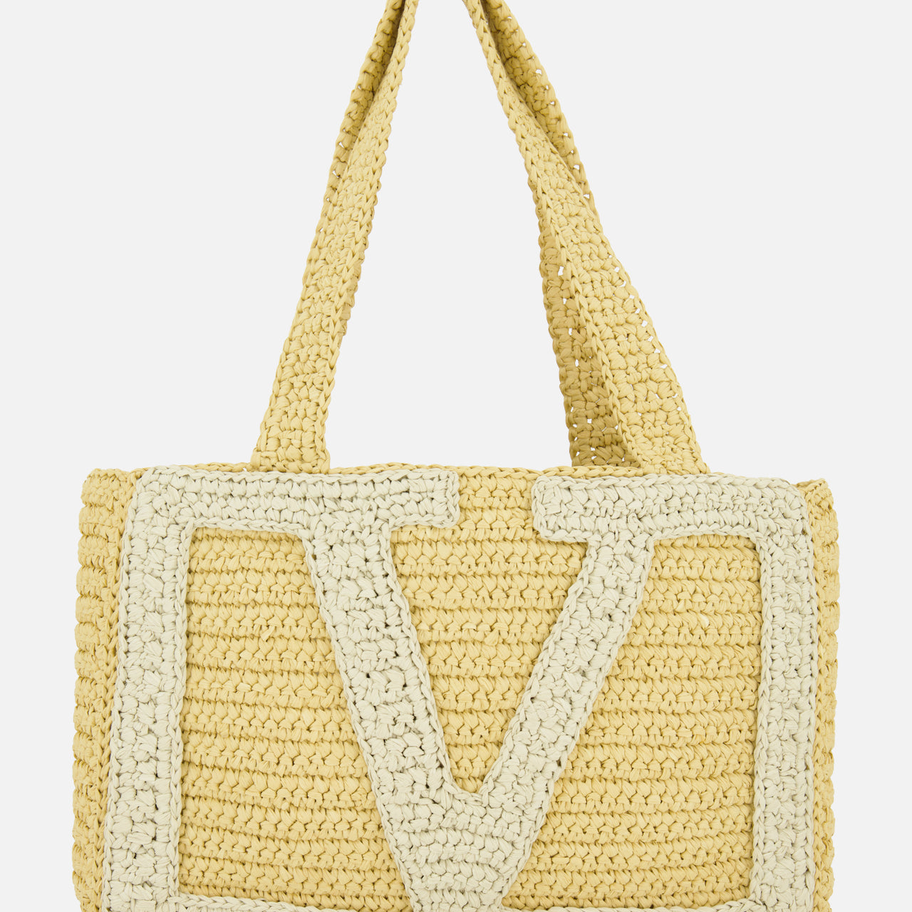 The VALENTINO GARAVANI Viva Superstar Crochet Medium Tote Bag features two handles, a large cream V design, and a natural woven texture—blending minimalist elegance with practicality for your next seaside outing.
