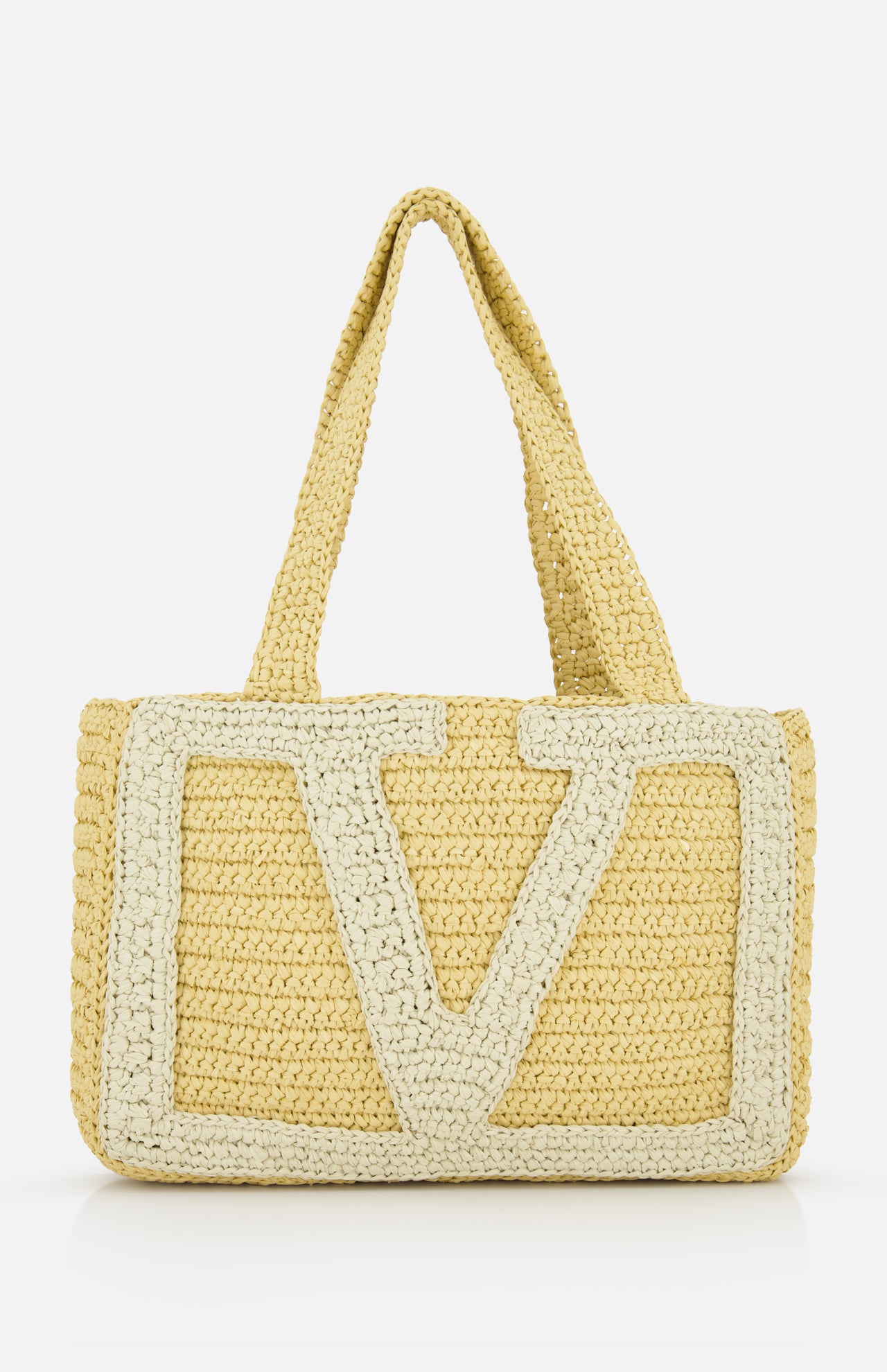 The VALENTINO GARAVANI Viva Superstar Crochet Medium Tote Bag features two handles, a large cream V design, and a natural woven texture—blending minimalist elegance with practicality for your next seaside outing.