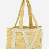 The Viva Superstar Crochet Medium Tote Bag by VALENTINO GARAVANI is a rectangular synthetic raffia beach bag with double handles and a large, textured light-colored V design on the front.