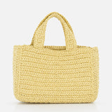 The VALENTINO GARAVANI Viva Superstar Crochet Small Tote Bag, a rectangular light yellow synthetic raffia bag with two short handles, is displayed on a plain white background.