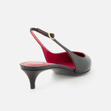 The VALENTINO GARAVANI VLogo Heartip Sling Back Heel features black leather, a pointed toe, low kitten heel, and red interior lining. Made in Italy, it's beautifully displayed against a white background.