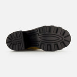 The image shows the black, textured rubber sole of the VALENTINO GARAVANI VLogo Signature Beatle Boot, viewed from the bottom against a plain white background. The sole, designed for these beige Chelsea boots, features deep, rugged treads for enhanced traction.