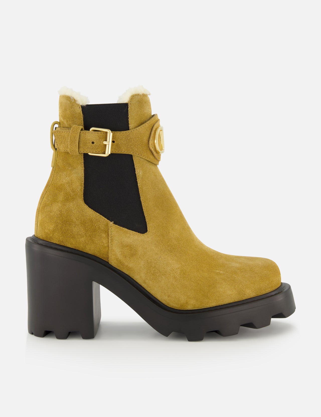 Introducing the VALENTINO GARAVANI VLogo Signature Beatle Boot: a mustard yellow suede ankle boot featuring a chunky black heel, rugged sole, side cutout, black elastic panel inspired by classic Chelsea boots in beige, gold buckle detail, and white shearling trim at the top.