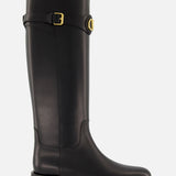 The VALENTINO GARAVANI VLogo Signature Boot is a black knee-high leather riding boot with a low heel, rounded toe, and gold-tone buckle detail at the top, shown against a plain white background.