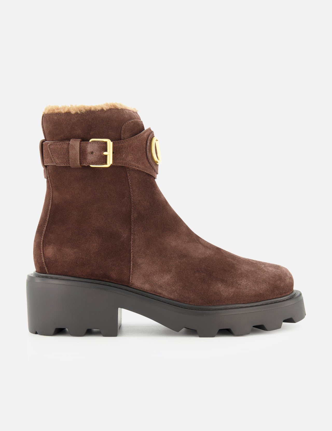 The VALENTINO GARAVANI VLogo Signature Sheepskin Bootie, featuring brown suede, a chunky black sole, luxurious sheepskin lining, and an elegant gold buckle, is showcased in side profile against a white background—an ideal fall choice for stylish comfort.