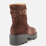 The VALENTINO GARAVANI VLogo Signature Sheepskin Bootie is shown from a rear angle against a plain white background, featuring brown suede, a chunky black sole, gold buckle detail, and visible tan sheepskin lining—making it a stylish addition to your fall boots collection.