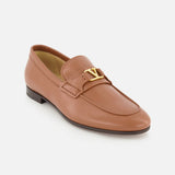 The VALENTINO GARAVANI VLogo Signature Loafer is a single tan leather shoe featuring an almond toe, low heel, and a gold VLogo signature detail on the strap, displayed on a white background.