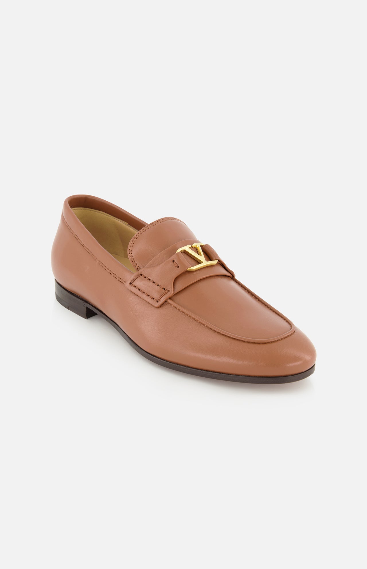 The VALENTINO GARAVANI VLogo Signature Loafer is a single tan leather shoe featuring an almond toe, low heel, and a gold VLogo signature detail on the strap, displayed on a white background.