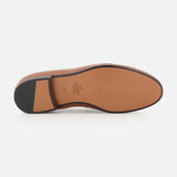 The image features the sole of the VALENTINO GARAVANI VLogo Signature Loafer, crafted in brown leather with a black heel and a smooth tan surface. Viewed from the bottom against a white background, the sole’s elegant design suggests an almond toe silhouette that embodies both style and sophistication.