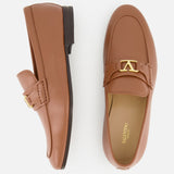 A pair of VALENTINO GARAVANI VLogo Signature Loafers in tan leather, featuring an elegant almond toe and gold buckle accents, displayed on a white background. One shoe is shown from the side, the other from above.