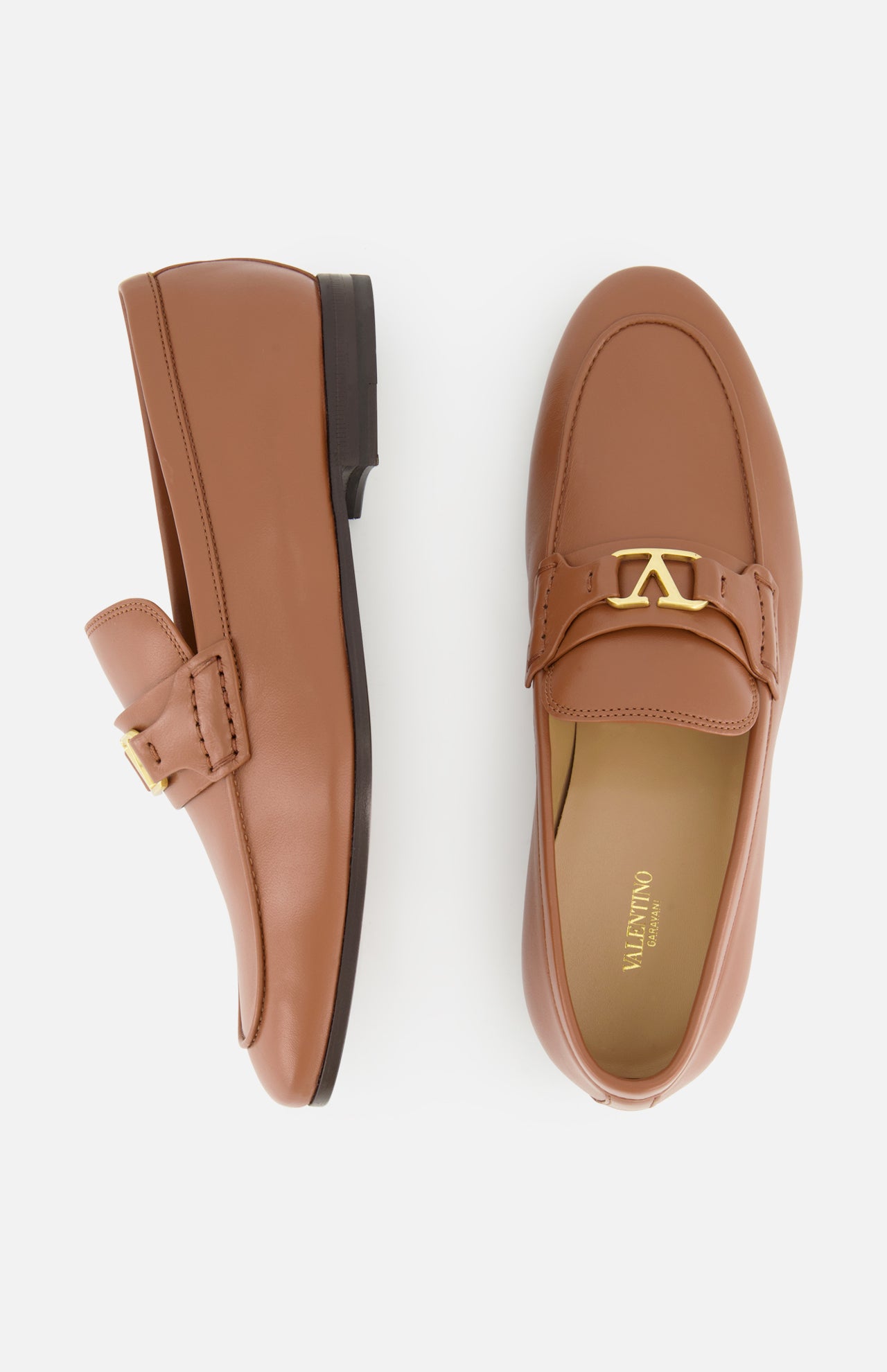 A pair of VALENTINO GARAVANI VLogo Signature Loafers in tan leather, featuring an elegant almond toe and gold buckle accents, displayed on a white background. One shoe is shown from the side, the other from above.