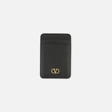 Valentino Garavani VLogo Signature Magnetic Card Holder in black leather featuring two slots and a gold V-shaped logo emblem.