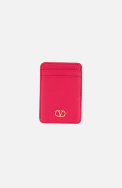 The VALENTINO GARAVANI VLogo Signature Magnetic Card Holder, crafted in bright pink leather, features two card slots and a gold Valentino logo at the bottom center. Displayed on a white background, this elegant accessory combines style and functionality in one chic design.