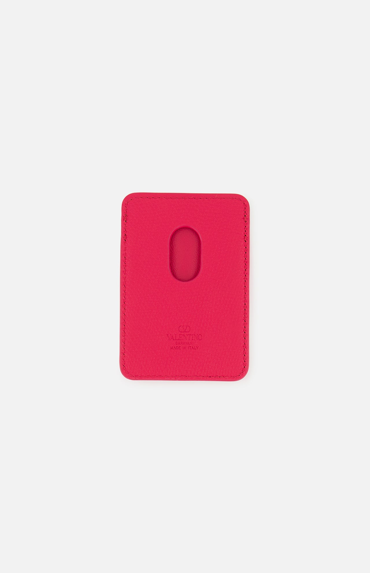 Displayed on a plain white background, the VALENTINO GARAVANI VLogo Signature Magnetic Card Holder features a vibrant pink leather design with an oval cutout in the center and embossed Valentino branding at the bottom.